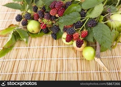 apples and raspberries on a wooden table