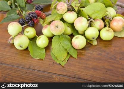 apples and raspberries on a wooden table