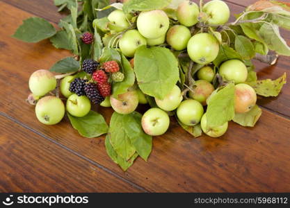 apples and raspberries on a wooden table