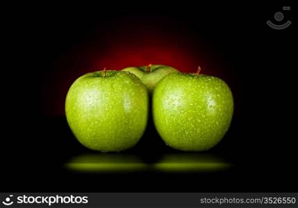 apples in red light isolated on black