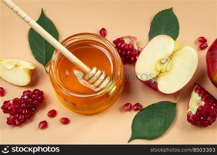 Apples, pomegranates and honey close-up on a yellow background. Happy Rosh Hashanah. Traditional religious Jewish holiday New Year.. Apples, pomegranates and honey close-up on yellow background. Happy Rosh Hashanah. Traditional religious Jewish holiday New Year.