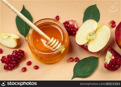 Apples, pomegranates and honey close-up on a yellow background. Happy Rosh Hashanah. Traditional religious Jewish holiday New Year.. Apples, pomegranates and honey close-up on yellow background. Happy Rosh Hashanah. Traditional religious Jewish holiday New Year.