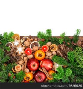Apples, tangerine fruits, walnuts, cookies and spices with christmas tree branches. Festive food background. Top view with space for your text