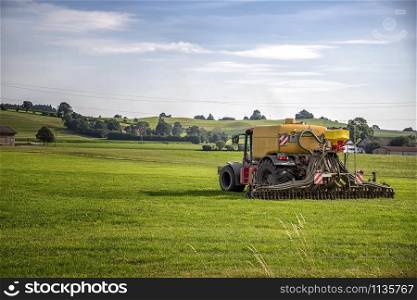 Application of manure on arable farmland with the heavy tractor who works at the field in Germany