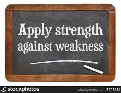 Apply strength against weakness - white chalk text on a vintage slate blackboard