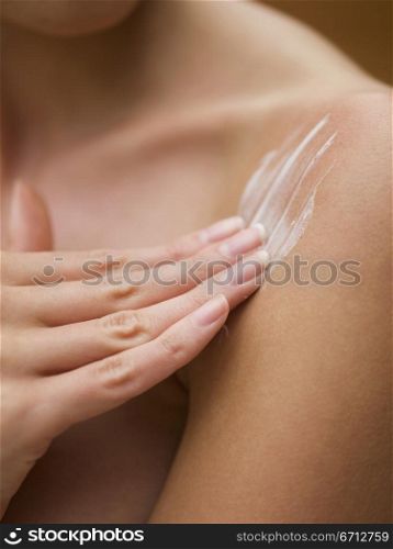 applying cream to shoulder