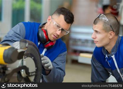 apprentice and man working in a factory