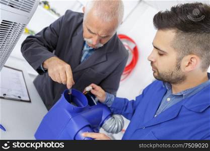 apprentice and teacher repairing an enginee