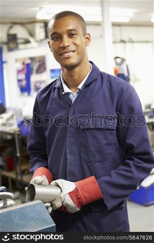 Apprentice Engineer Working On Factory Floor