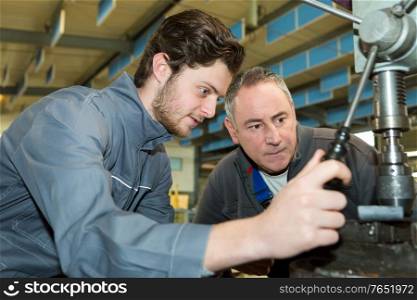apprentice factory worker learning the trade with mentor