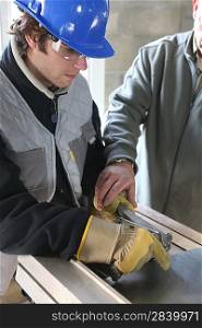 Apprentice learning how to cut sheet metal