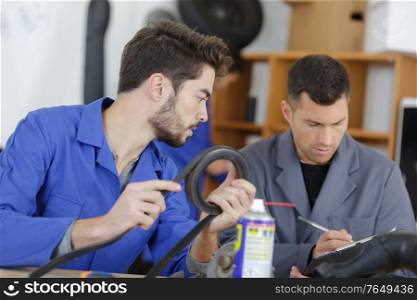 apprentice mechanic holding pipe
