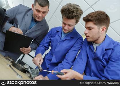 apprentice mechanics working in auto repair shop