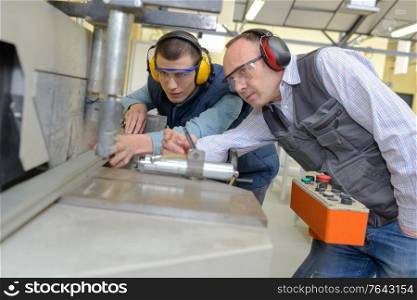 apprentice working on machine with mentor