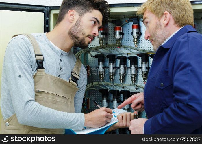 apprentice workman filling in form with supervisors help
