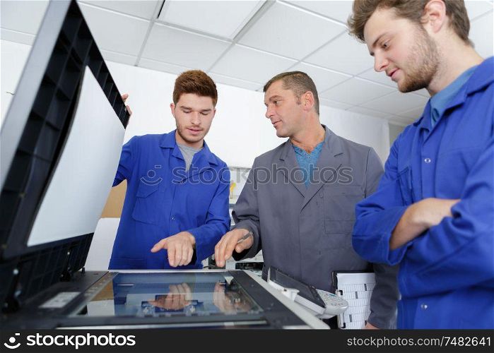 apprentices learning to fix photocopier
