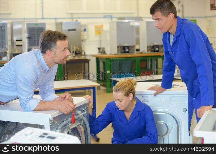 Apprentices looking at washing machines