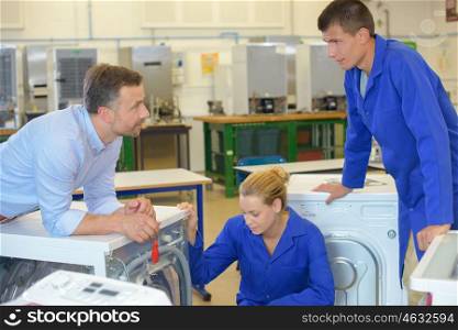 Apprentices looking at washing machines
