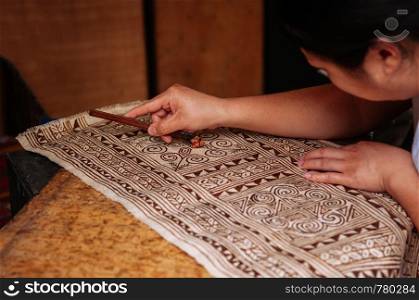 APR 4, 2018 Luang Prabang, Laos - Hilltribe Laotian woman working on Batik fabric painting. Culture tourism at Ock Pop Tok handicraft center