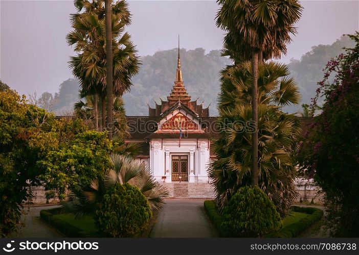 APR 4, 2019 Luang Prabang, Laos - Luang Prabang Royal Palace Museum main building among palm tree in peaceful morning