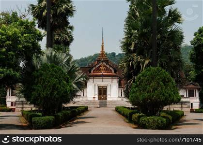 APR 5, 2019 Luang Prabang, Laos - Luang Prabang Royal Palace Museum main building among palm tree in peaceful morning