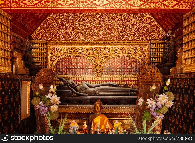 APR 5 Luang Prabang, Laos -Beautiful old golden reclining Buddha hall mural art wall at Wat Xieng thong,