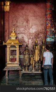 APR 5 Luang Prabang, Laos - Tourist exploring and looking at antique old Buddha statues at Wat Xieng thong museum. Most Famous tourist attraction in World heritage zone