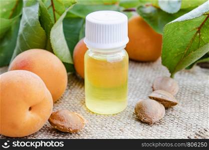 Apricot flavor oil and fresh apricots on a wooden table. Selective focus.. Apricot flavor oil and fresh apricots on a wooden table.