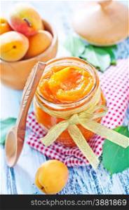 apricot jam in glass bank and on a table