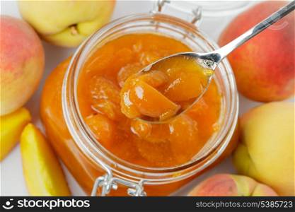 Apricot jam with fresh fruits isolated on white