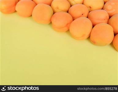 Apricot on a yellow background, arranged on top right corner, with copy space. Top view, close up.. Apricot on a blank background, arranged on top right corner, with copy space. Top view, close up.