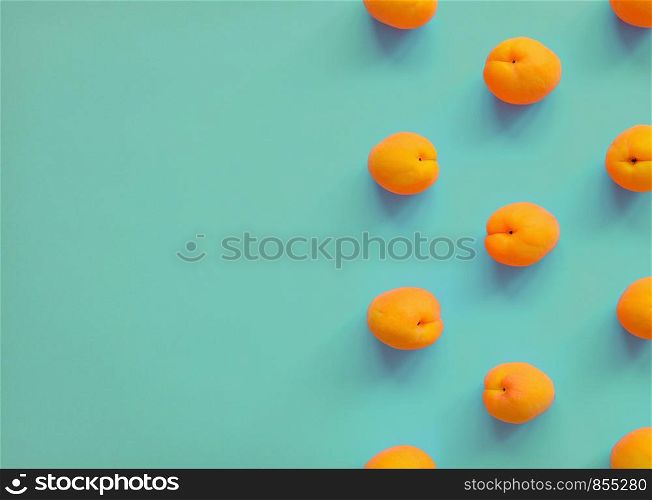 Apricot on turquoise background. Apricot pattern. Top view, flat lay. Summer fruit. Copy space. Apricot on bright background. Apricot pattern. Top view, flat lay. Summer fruit
