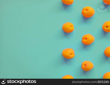 Apricot on turquoise background. Apricot pattern. Top view, flat lay. Summer fruit. Copy space. Apricot on bright background. Apricot pattern. Top view, flat lay. Summer fruit