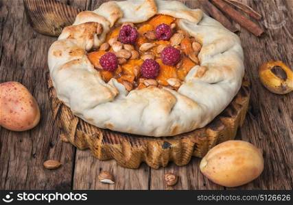 Apricot tart flan. Apricot cake on a rustic old table with fruits
