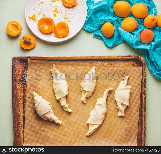 Apricots croissants preparation. Rolled dough on baking sheet . French pastry goods