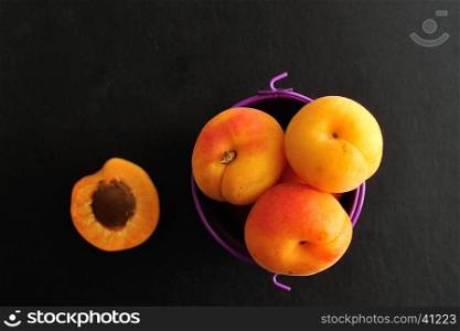 Apricots in a purple bucket. Top view.