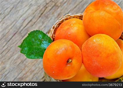 Apricots on the old wooden table and basket shoot in studio