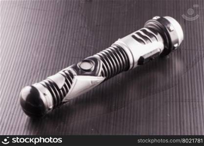 APRIL 6, 2016: toy lightsaber from Star Wars over black background. Star Wars is the most famous science fiction movie franchise of the world.