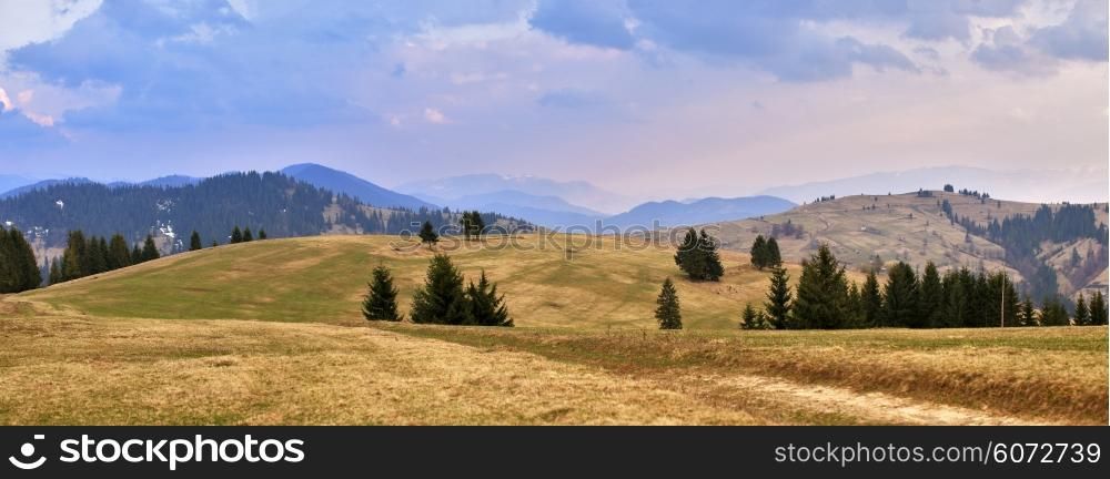 April evening in Carpathian mountains. Spring hills and fields.