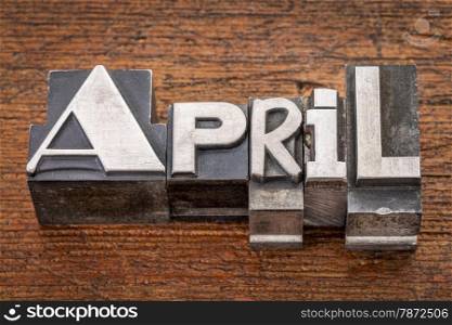 April word in mixed vintage metal type printing blocks over grunge wood