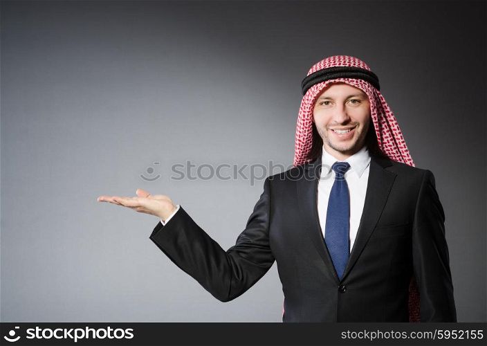 Arab businessman holding hands against grey background