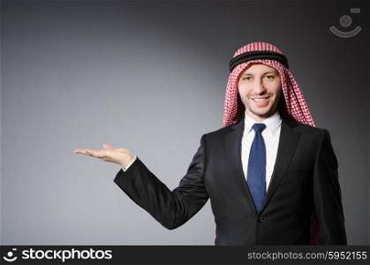 Arab businessman holding hands against grey background