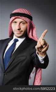 Arab businessman pressing virtual buttons against grey background