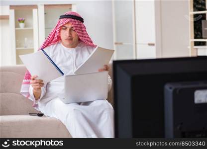 Arab businessman watching tv at home