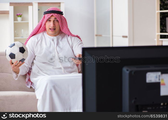 Arab businessman watching tv at home