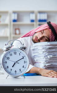 Arab businessman working in the office doing paperwork with a pi. Arab businessman working in the office doing paperwork with a pile of papers