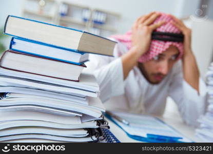 Arab businessman working in the office doing paperwork with a pi. Arab businessman working in the office doing paperwork with a pile of papers