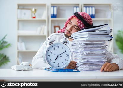 Arab businessman working in the office doing paperwork with a pi. Arab businessman working in the office doing paperwork with a pile of papers