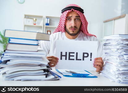 Arab businessman working in the office doing paperwork with a pi. Arab businessman working in the office doing paperwork with a pile of papers