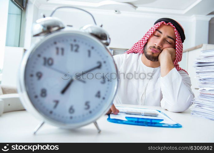 Arab businessman working in the office doing paperwork with a pi. Arab businessman working in the office doing paperwork with a pile of papers